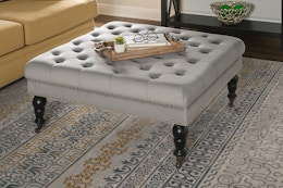 Lifestyle image of the Isabelle Gray Velvet Tufted Square Accent Ottoman in living room setting