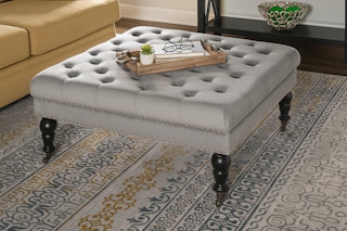 Lifestyle image of the Isabelle Gray Velvet Tufted Square Accent Ottoman in living room setting