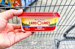 hand holding a tub of land o lakes butter