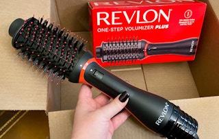 hand holding a revlon one step volumizer plus over a box