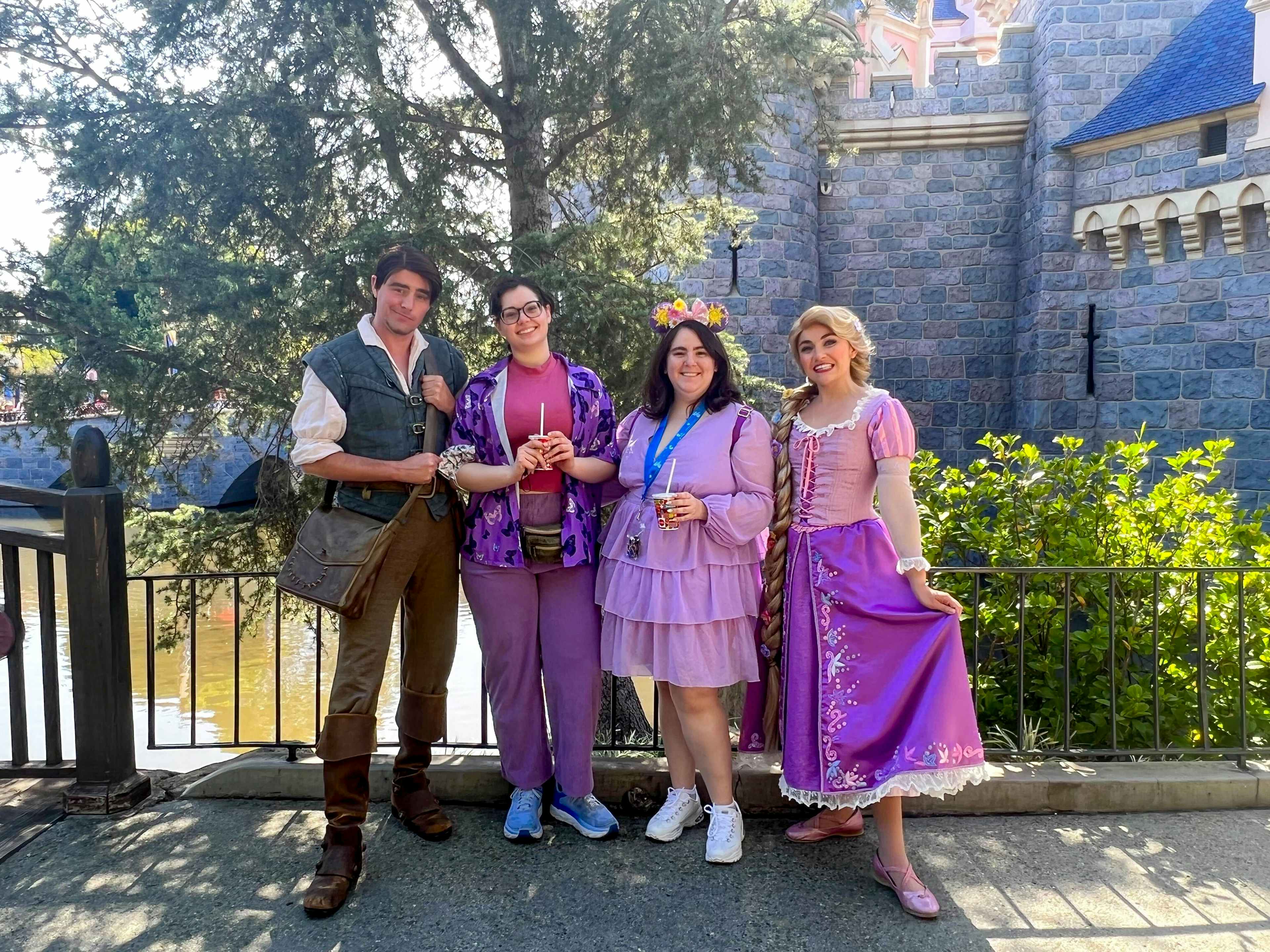 two people posing with some disney cast members dressed as rapunzel and flynn rider