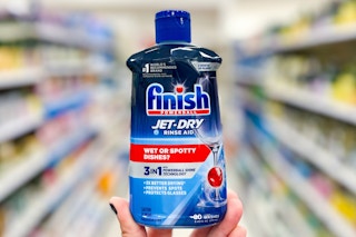 hand holding a bottle of finish jet dry rinse aid in a store aisle