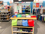 A Nike display shelf with Nike clothes sitting in it.