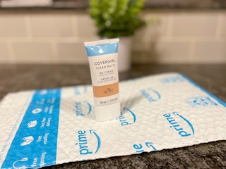 A container of Covergirl BB Cream on an Amazon envelope.