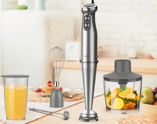 an immersion blender set on a table with food