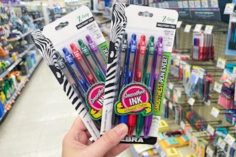 hand holding two packs of zebra pens