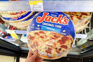 person grabbing a frozen pizza from the cooler