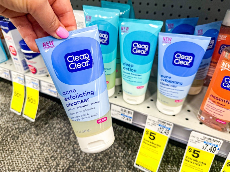 person grabbing a bottle of clean and clear cleanser from the shelf