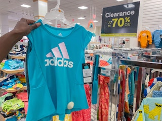someone holding a blue kids adidas shirt
