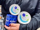 Three Nivea products being held be someone in Walmart store (close up shot)
