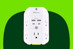 A surge protector has two AC outlets on each side, 4 USB ports and one AC outlet in the front, and a dusk-to-dawn night light on the bottom.