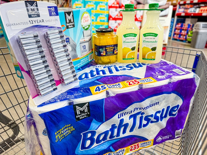 toilet paper, batteries, trash bags, pineapple, and lemonade in a cart