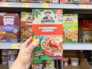 quaker instant strawberry banana oatmeal held in front of walmart shelf