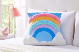 Lifestyle image of a rainbow snuggly pillow from the brand Your Zone at Walmart