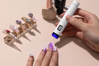 a uv lamp being held over nails