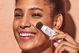 Person Using Hawaiian Tropic Mineral Powder Sunscreen Brush on their face