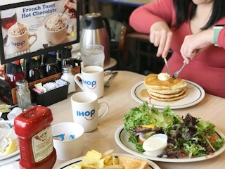 A person cutting into a pancake at ihop