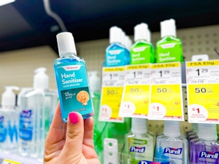 person holding a bottle of hand sanitizer in front of the shelf