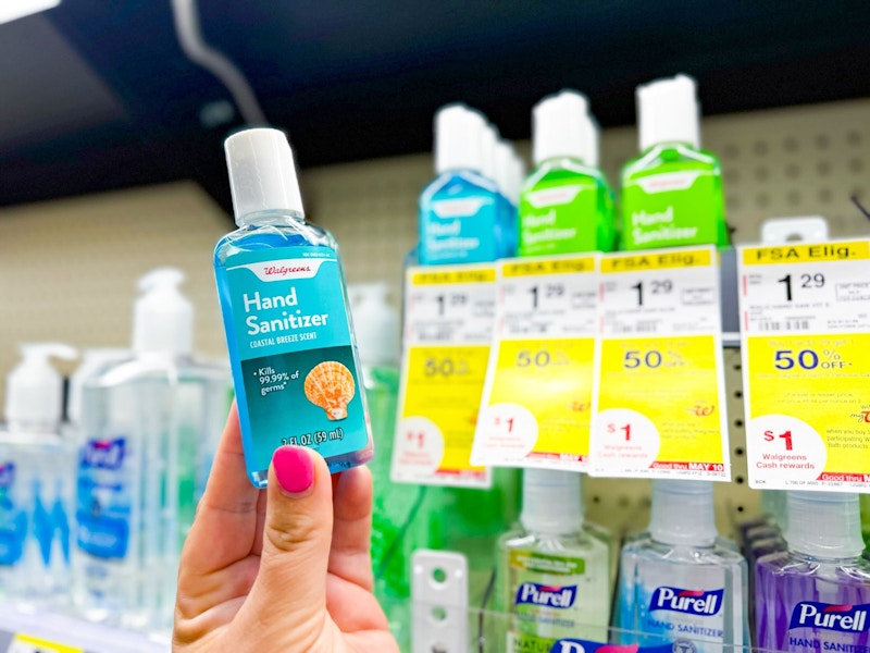 person holding a bottle of hand sanitizer in front of the shelf