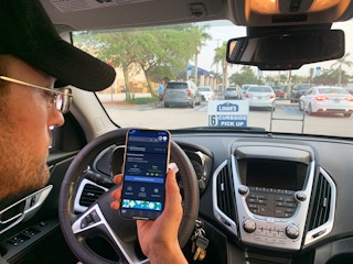 car parked in lowes curbside pickup with a person holding up a phone