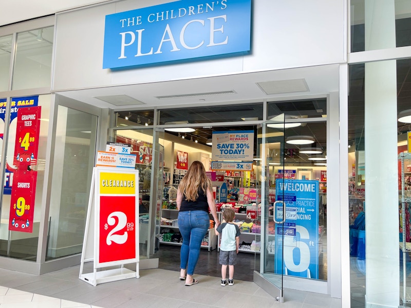 a mom and child walking into the children's place