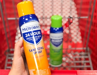 hand holding bottle of Microban in front og shoppping cart with another bottle of Microban