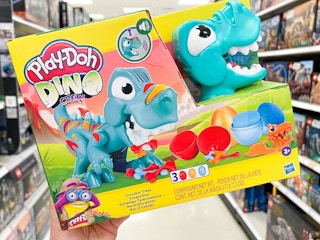 a person holding up a play doh toy in a store
