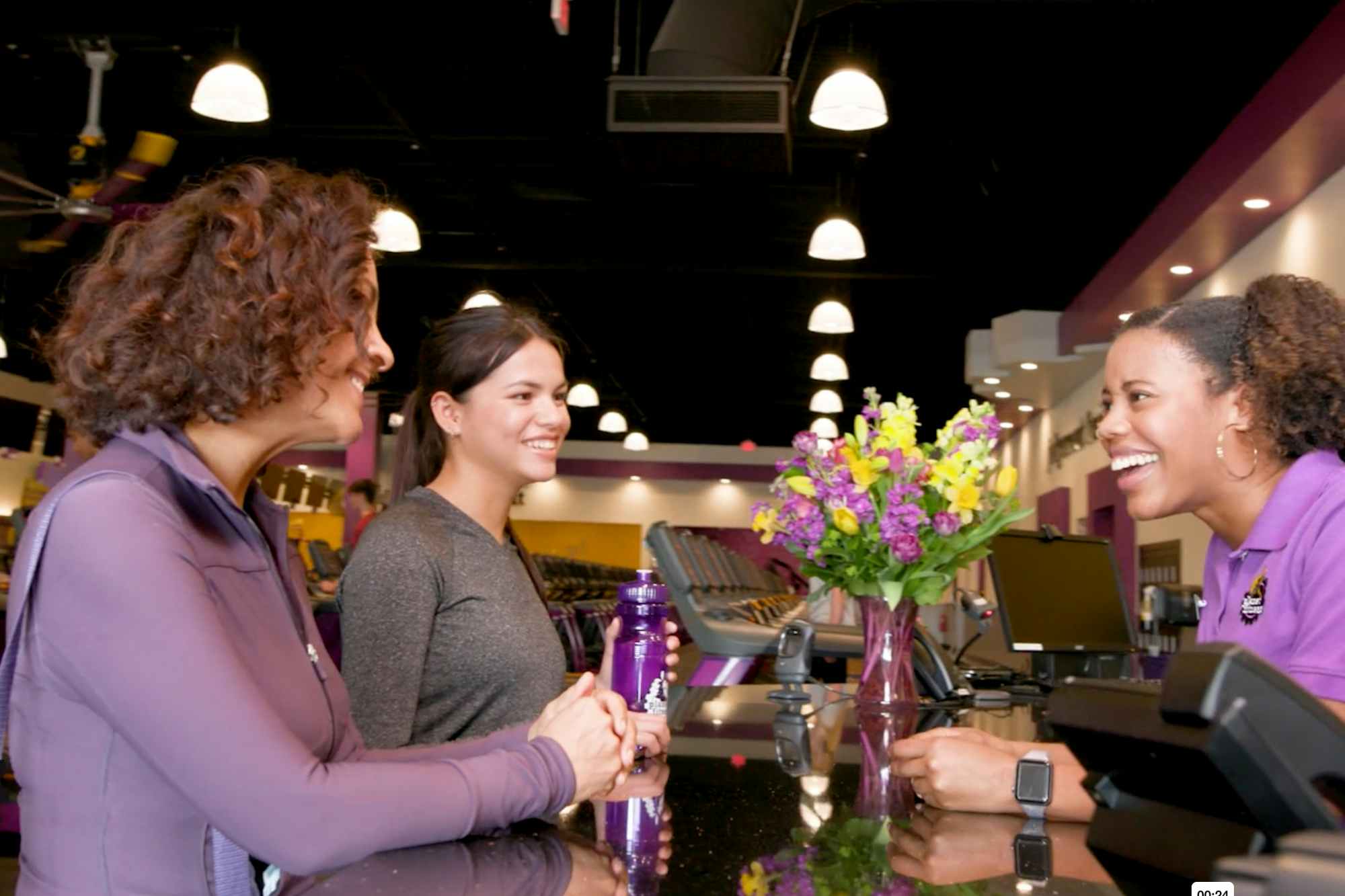 A mother and teen talking to a Planet Fitness employee