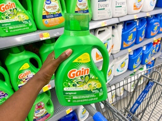 A bottle of Gain Liquid Laundry Detergent held in laundry care aisle at Walmart