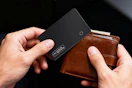 person pulling card tracker out of wallet