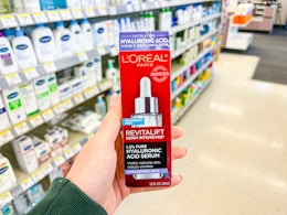hand holding loreal revitalift serum in walgreens