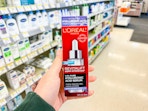 hand holding loreal revitalift serum in walgreens