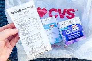 someone holding up a CVS receipt next to products and bag