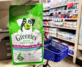 bag of greenies dog food on a shelf with a petsmart cart behind it
