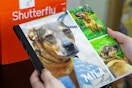 someone holding an 8x8 photo book of their pet from shutterfly
