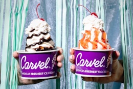 Two people holding a Carvel sundae in one hand.