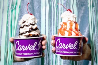 Two people holding a Carvel sundae in one hand.