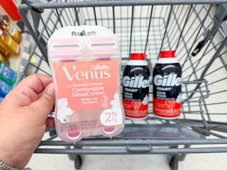 hand holding venus razors and gillette shave foams in walgreens cart