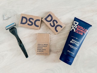 An array of Dollar Shave Club products including a razor handle, three cartridges of four-count blades, and DSC Shave Butter
