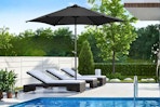 Lifestyle image of a black Ainfox patio umbrella outdoors near a pool