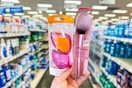 person holding a makeup sponge set and a makeup brush in an aisle