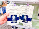 holding a pack of gerber baby bodysuits in front a target shelf