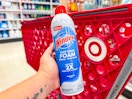 hand holding windex foam spray in front of a target cart