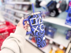 hand holding a playstation tumbler in front of target 