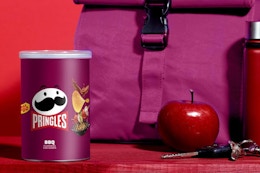 a purple can of Pringles next to a lunch bag