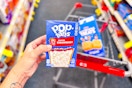 person holding a box of pop tarts over a cart with rice krispies treats in it