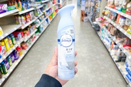 hand holding a bottle of febreze air in a store aisle