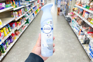 hand holding a bottle of febreze air in a store aisle