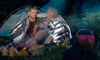 two people in front of a tent with an emergency thermal blanket around them