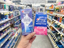 hand holding crest whitening serum and whitestrips in walgreens